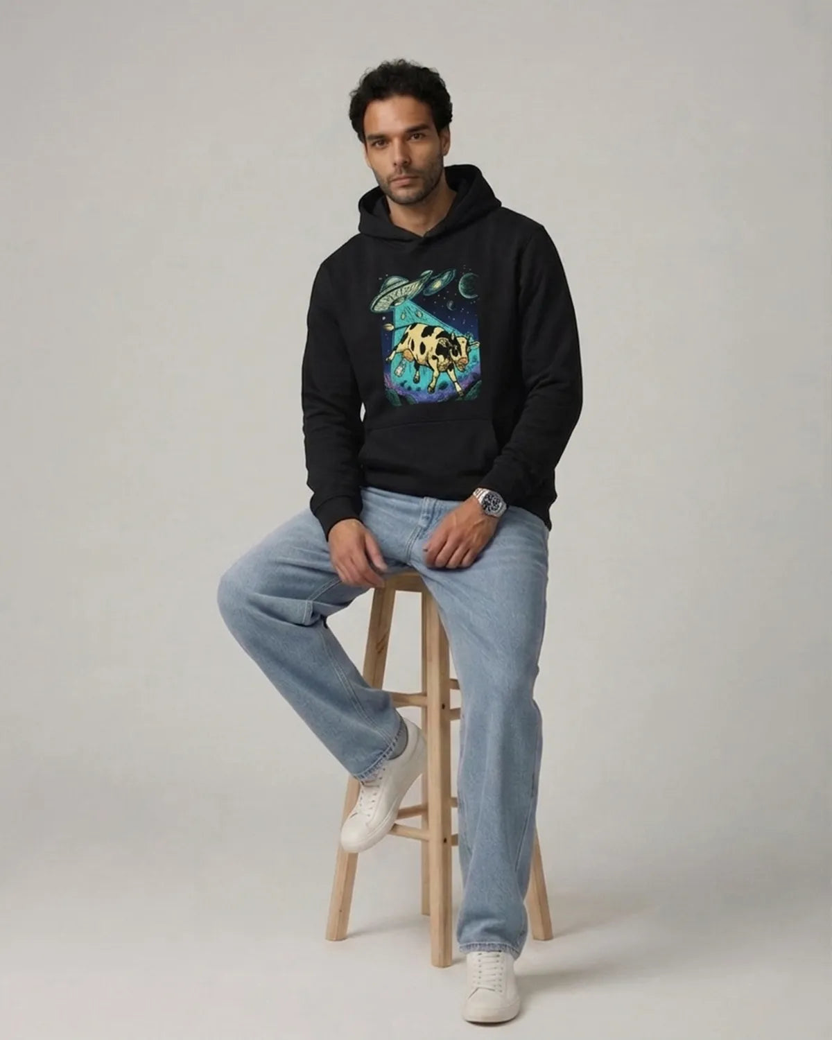 Stylish cosmic cow print hoodie designed with a soft fabric blend, ribbed cuffs, front pocket, and bold artistic artwork.